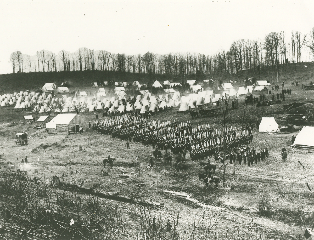 A black-and-white photo taken from far away showing soldiers marching. They are the 96th Pennsylvania.