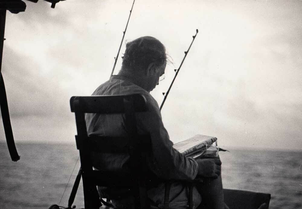 Ernest Hemingway reading on his boat