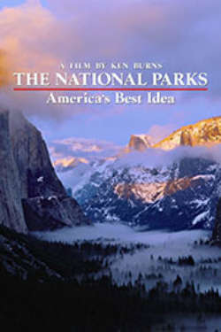 A color poster for the film "The National Parks: America's Best Idea." It depicts a sweeping vista between enormous, fog-draped mountain ranges, ringed in purple and gold colors.