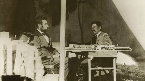 A sepia-toned photo showing Abraham Lincoln and General George McClellan seated, looking at one another, in Antietam, Maryland, circa 1862. | Episode 3 | Forever Free (1862)