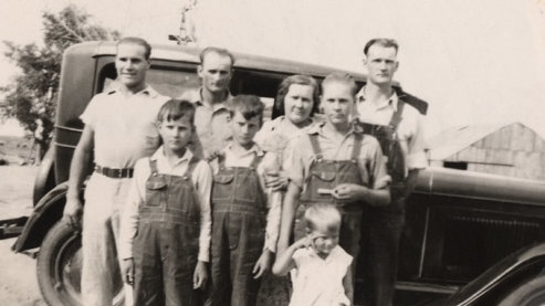The Coen family standing in front of an auto. Floyd is standing at the center in overalls and Dale is to his left. Morton County, Kansas. 1935. | About the Participants
