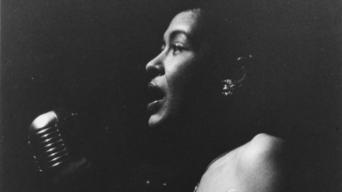 Black-and-white photo depicting Billie Holiday singing on stage in Rochester, New York, in 1957. | A Note from Ken Burns