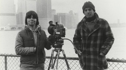 A black-and-white photo taken in the 1980s depicting Ken Burns standing next to another man and a camera on a tripod. | A Note from Ken Burns