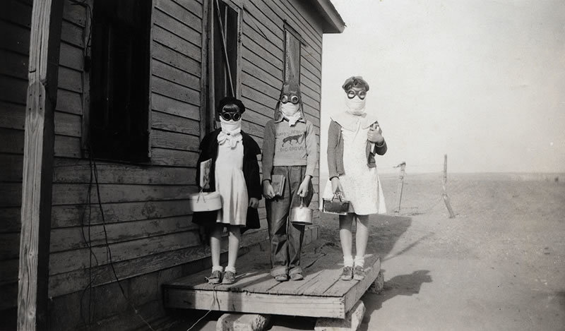 Three children prepare to leave for school wearing goggles and homemade dust masks to protect them from the dust in Lakin, Kansas.